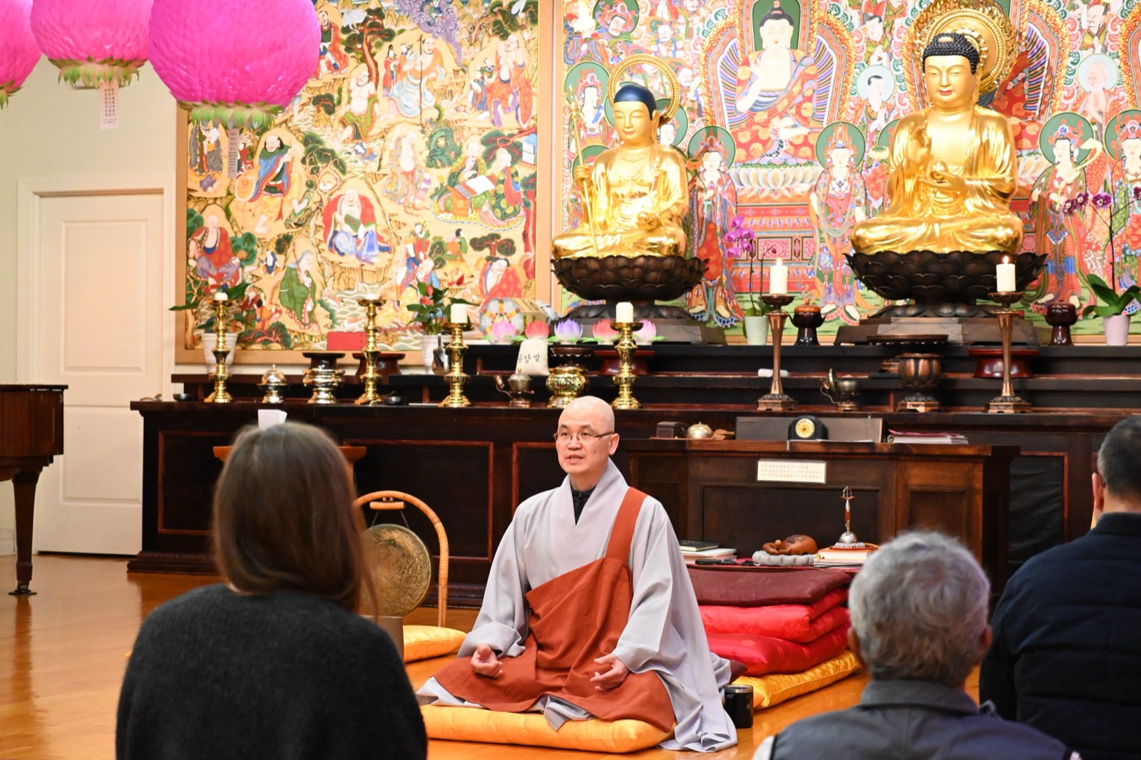 Venerable SooSeong gives a Dharma talk before the golden Buddhas at Bul Kwang Zen Center.